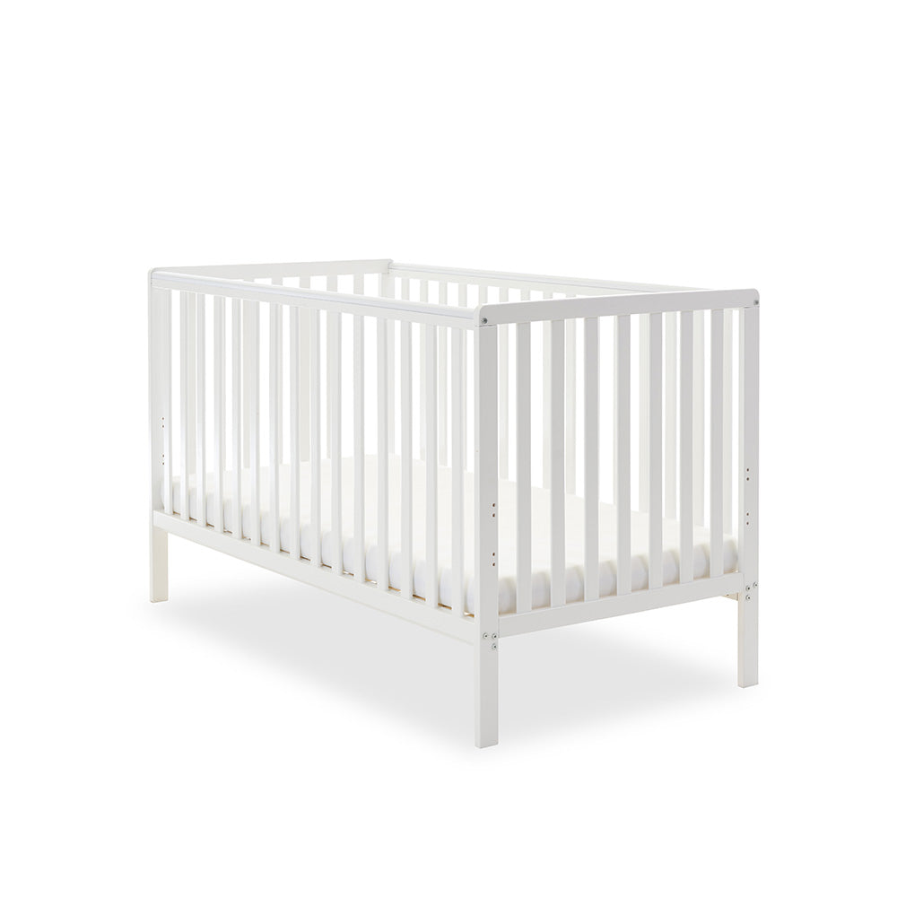 White cot bed with rails on all 4 sides, teething rails on 2 longest sides, base set on the lowest setting.