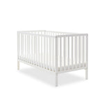 White cot bed with rails on all 4 sides, teething rails on 2 longest sides, base set on the lowest setting.