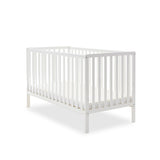 White cot bed with rails on all 4 sides, teething rails on 2 longest sides, base set on the lowest setting.