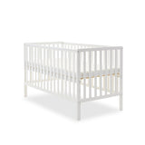 White cot bed, with rails on 4 sides, teething rail & base on heighest setting.