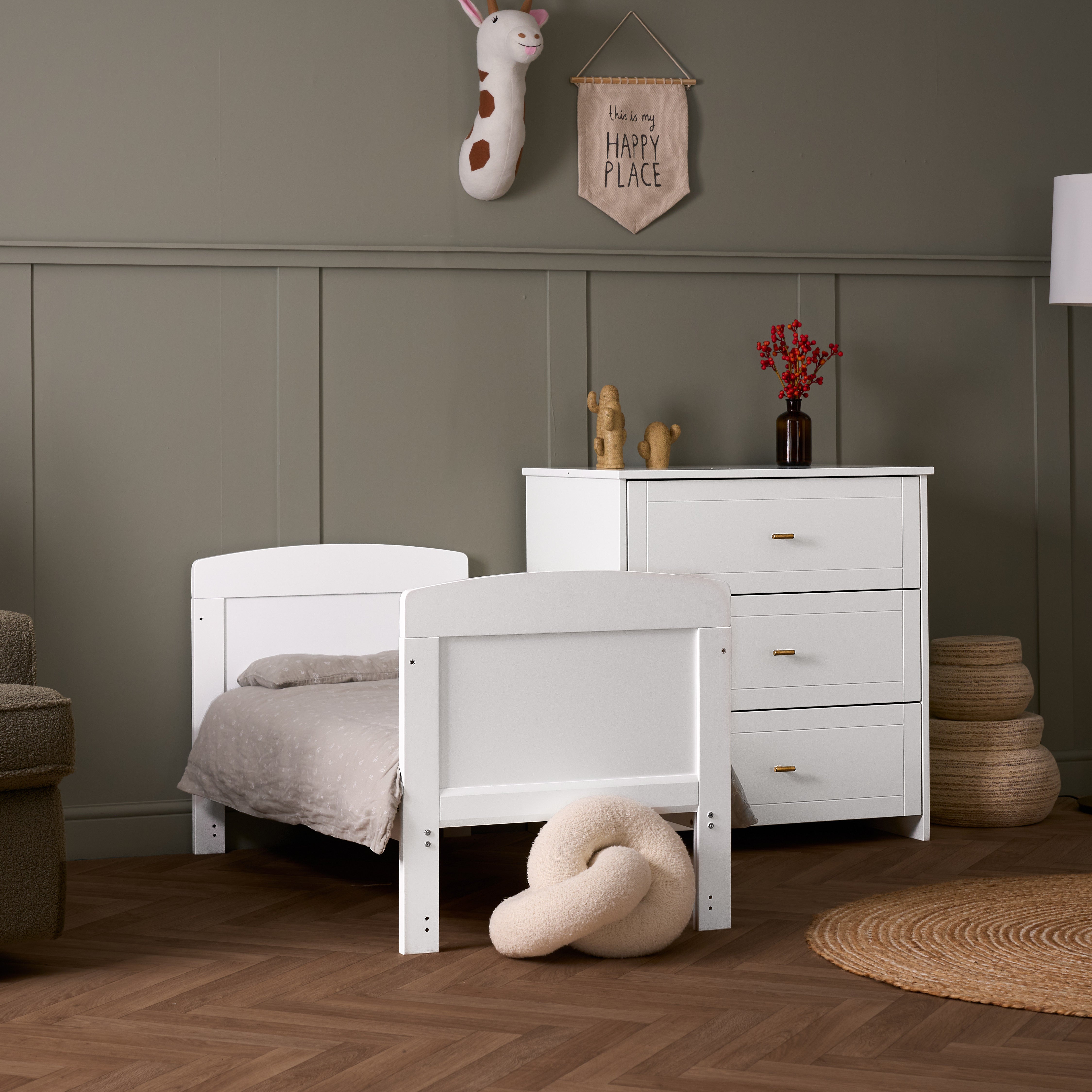 White Mini Cot Bed converted into a toddler bed, with matching 3 drawer dresser, with gold T bar handles.