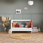 Cot bed that converts into day bed by removing one side