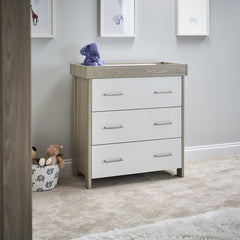 Changing unit with 3 drawers with metal handles.