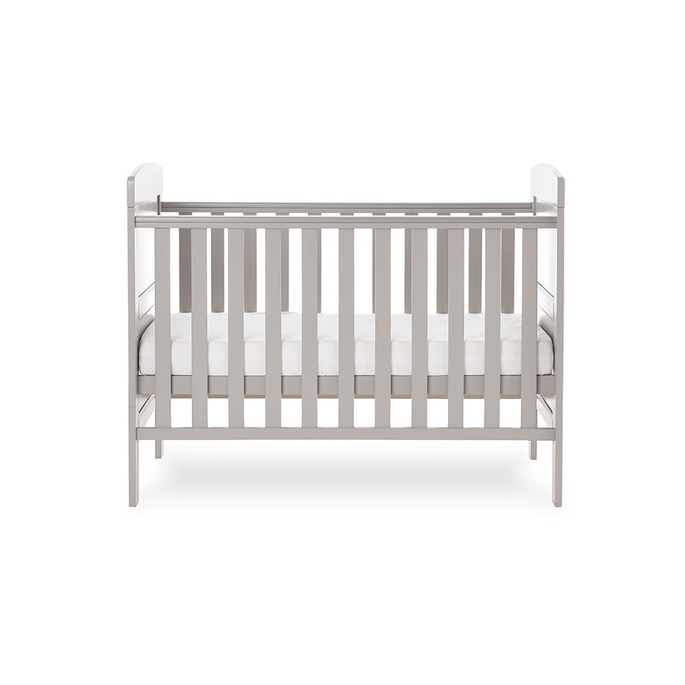 Mini cot bed with solid ends, curved tops, teething rails on the side rails & base on the middle setting.