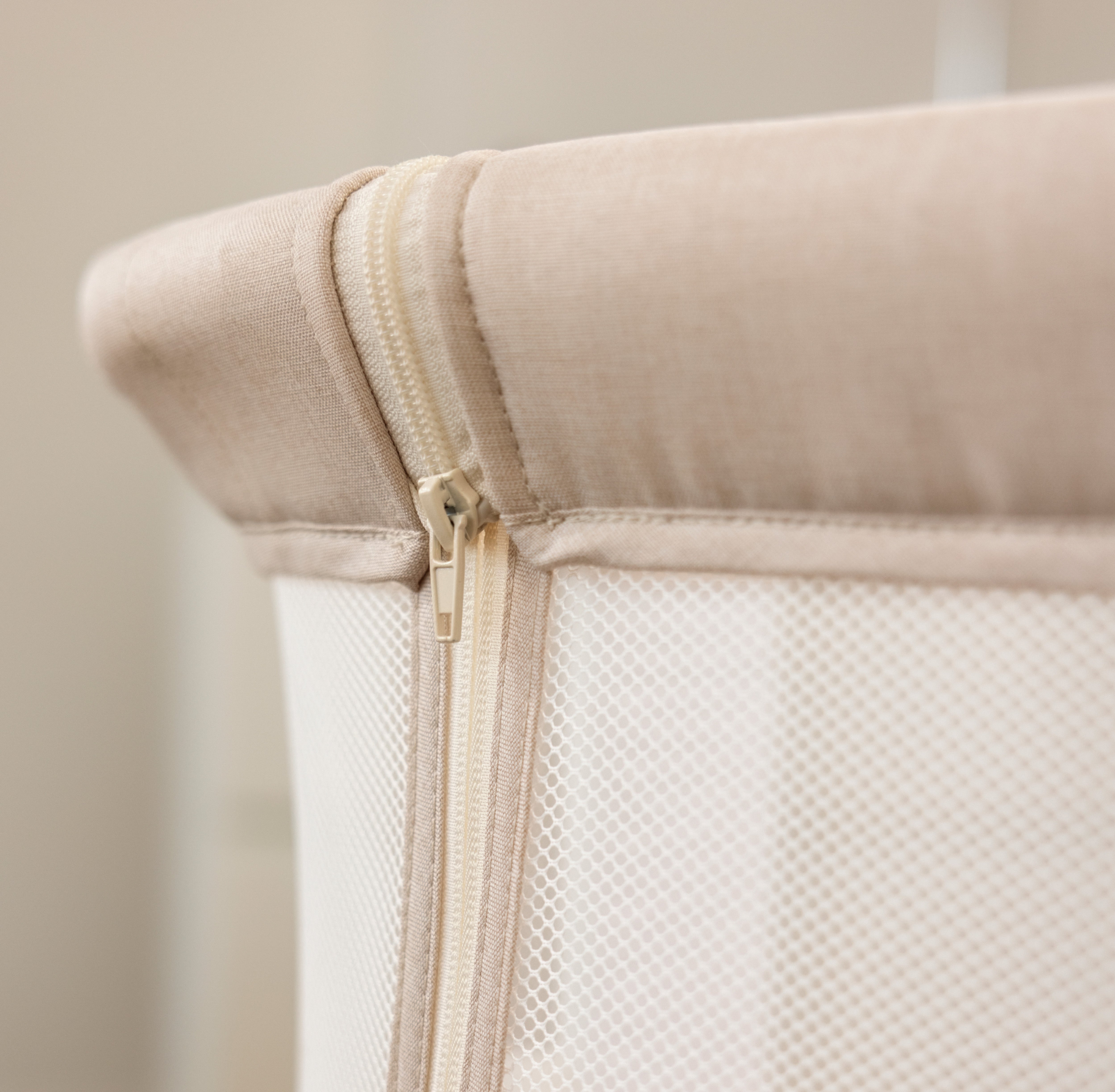 Bedside crib, oatmeal colour close up of the zip on parent mesh panel