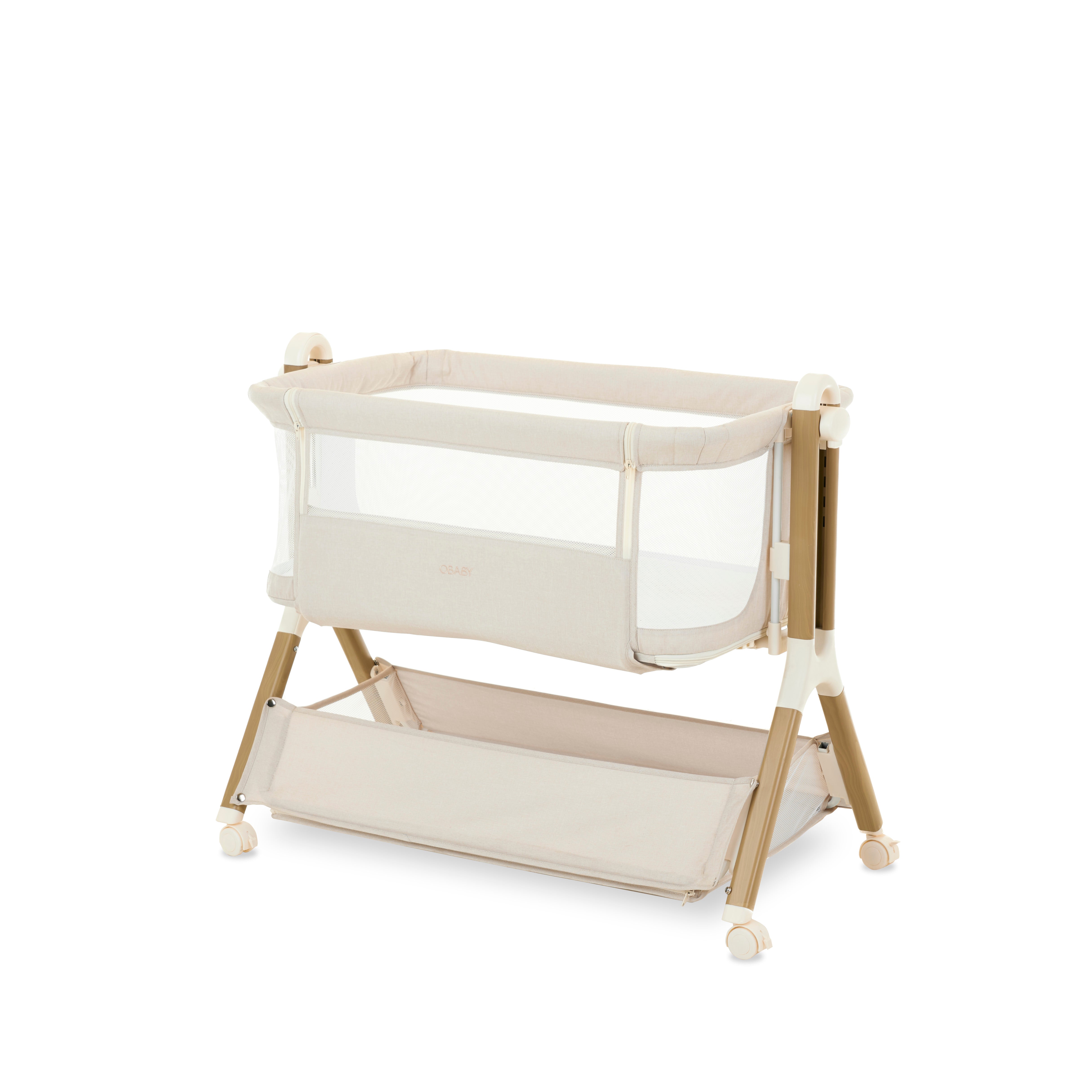 Obaby Cloud Bedside Crib in oatmeal colour with breathable mesh sides and adjustable height, designed to be placed beside a bed.