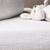 White plush toy on a textured gray surface