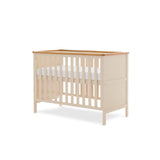 Mini Cot bed, solid end with trim on top, base on the new born setting.