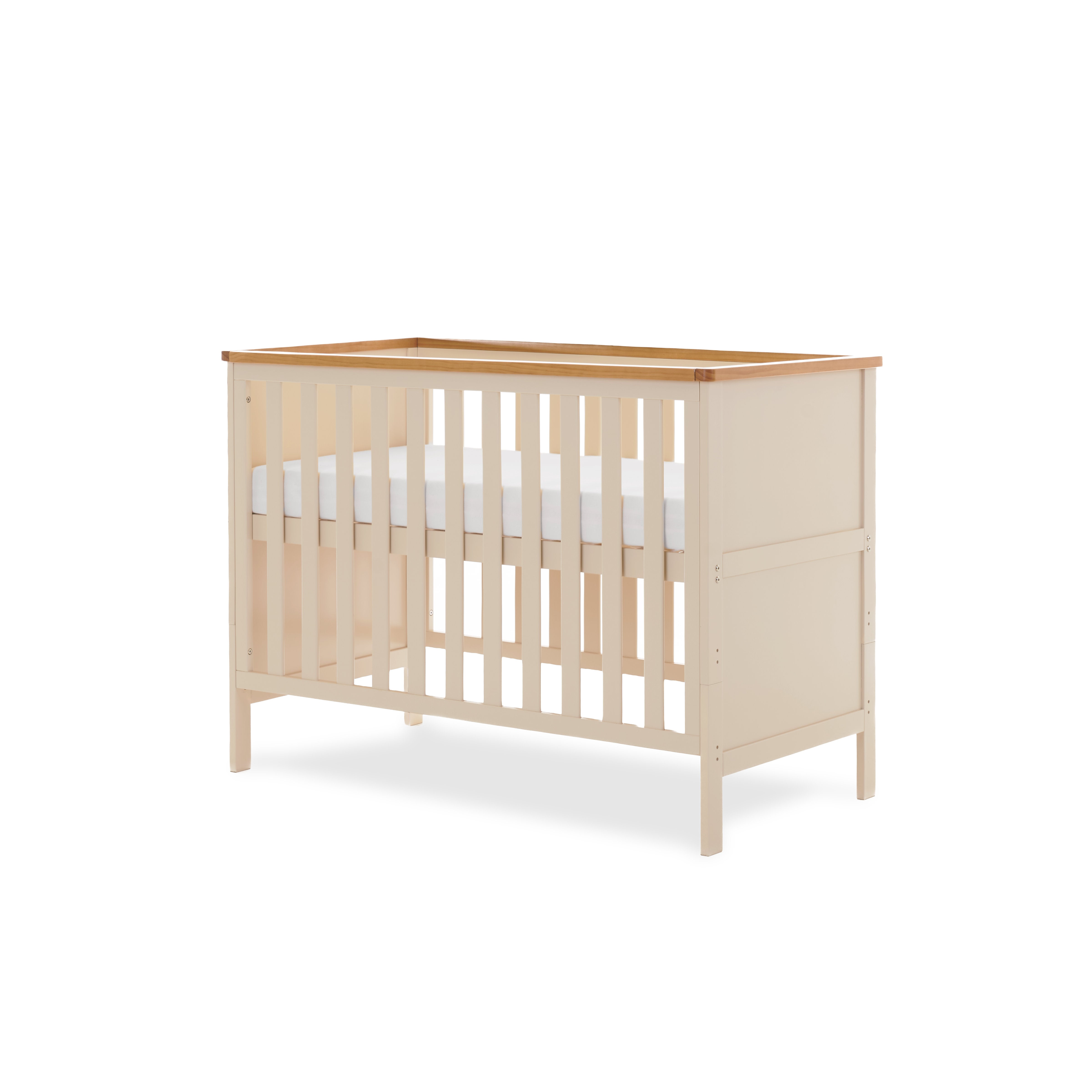 Mini Cot bed, solid end with trim on top, base on the new born setting.