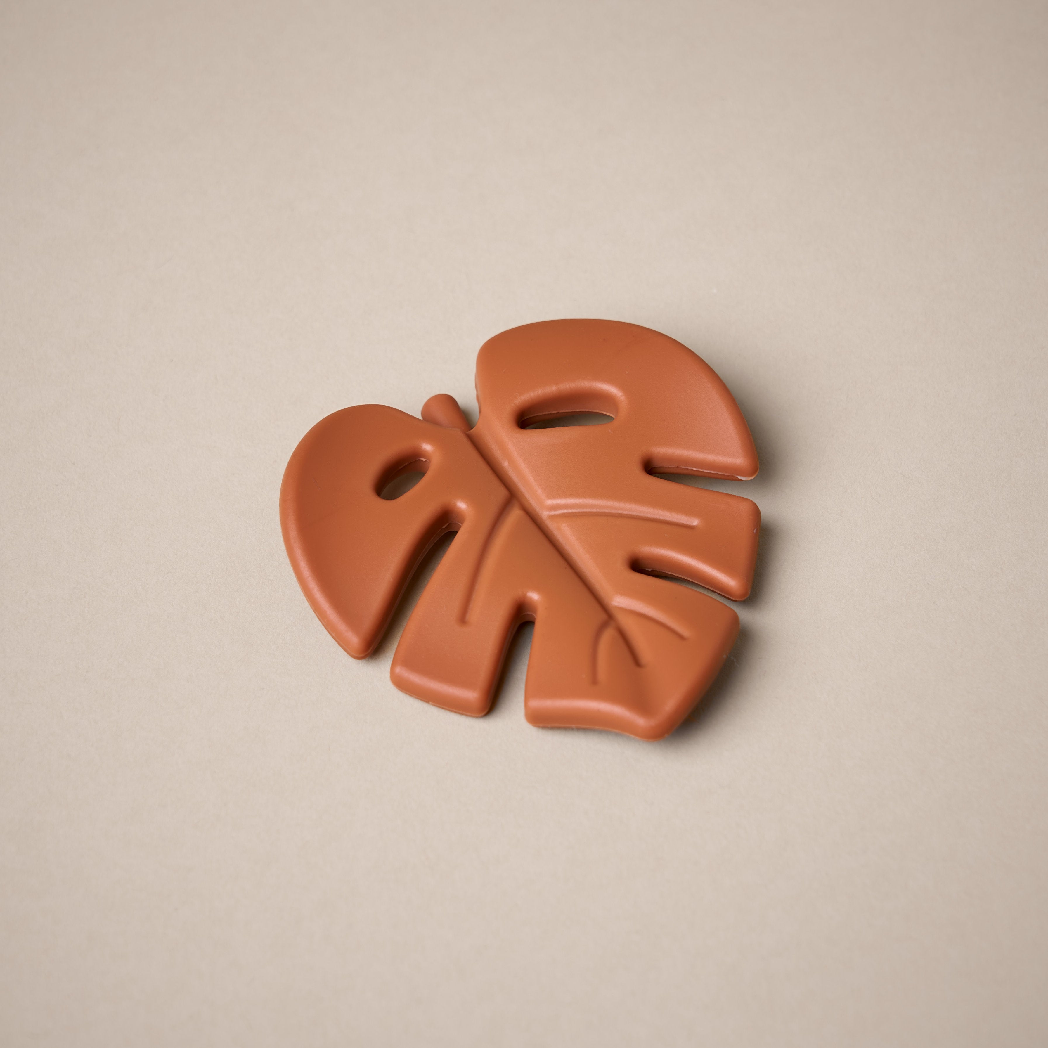 Leaf shaped teether in burnt orange colour