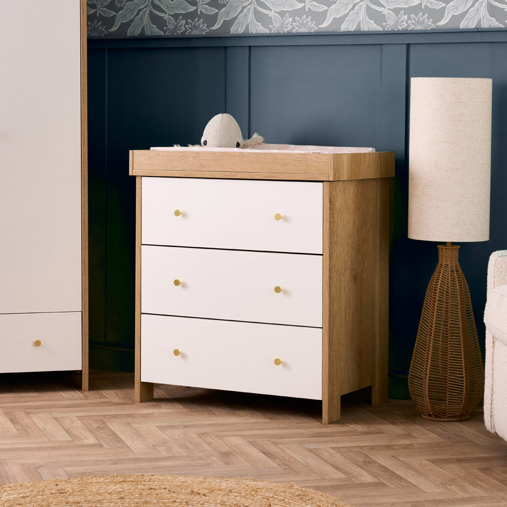 3 drawer changing unit with oak sides & white drawer fronts finished off with gold round handles, baby changing top that can be removed, so ideal for lifetime storage.