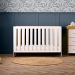 Contemporary cot bed with oak ends & thick white rails with teething rails. Based fitted on the lowest setting. 