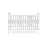 Side of cot bed, with base on new born setting, pink trim on ends.