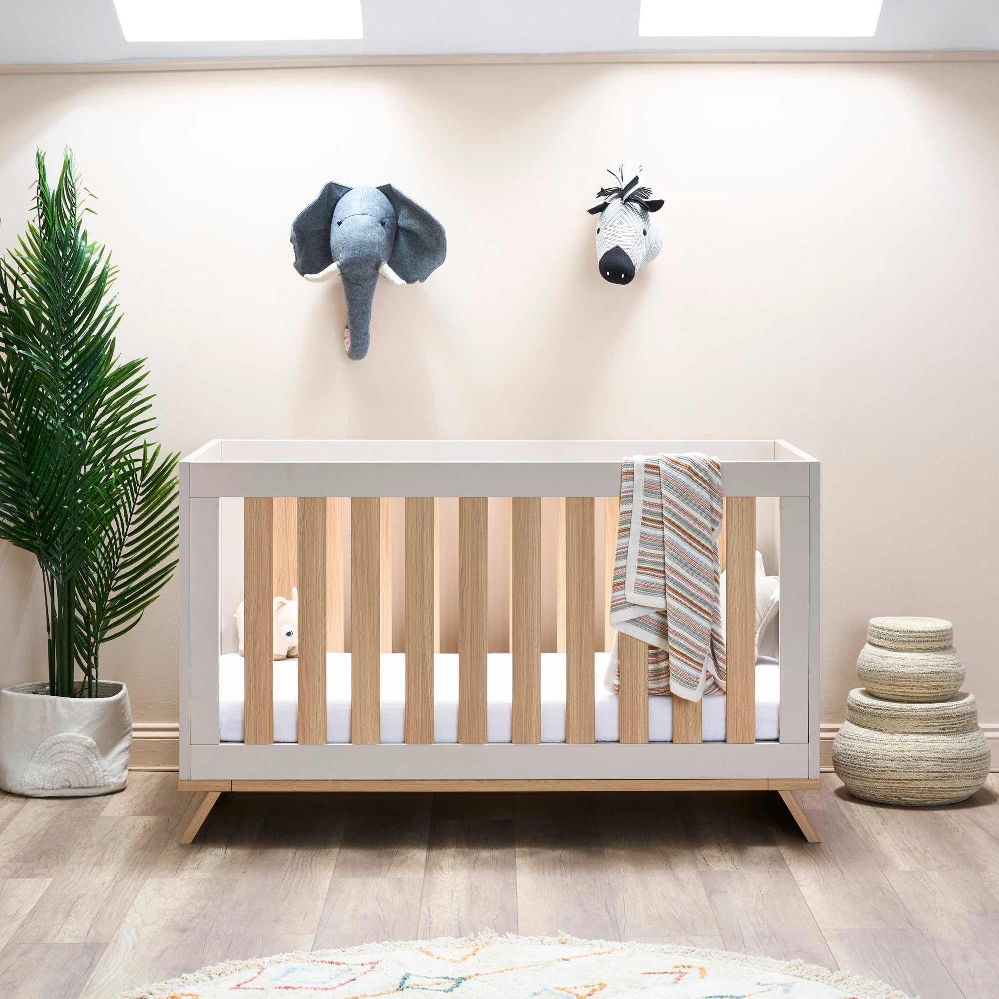 Modern Cot bed in cashmere colour with oat rails & scandi style feet. 