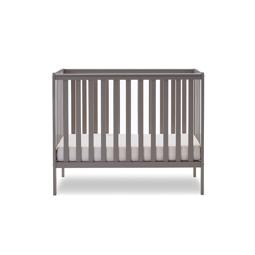 compact cot with rails on all 4 sides, base at the lowest setting.