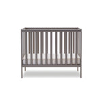 compact cot with rails on all 4 sides, base at the lowest setting.