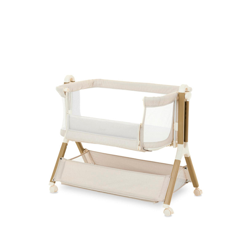 45 degree angle of bedside crib on heigest setting, oatmeal fabric with mesh sides, parent side has unzipped panel that can be opened for easy access to the baby. wood effect frame & storage basket underneath. Caster wheels to move into position easily. 