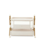 bedside crib on lower setting, oatmeal fabric with mesh sides, parent side has zipped panel that can be opened for easy access to the baby. wood effect frame & storage basket underneath. Caster wheels to move into position easily. 