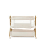 bedside crib on middle setting, oatmeal fabric with mesh sides, parent side has zipped panel that can be opened for easy access to the baby. wood effect frame & storage basket underneath. Caster wheels to move into position easily. 