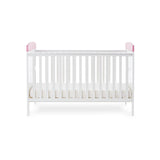 Cot Bed with base on lowest setting, solid ends with pink trim. 