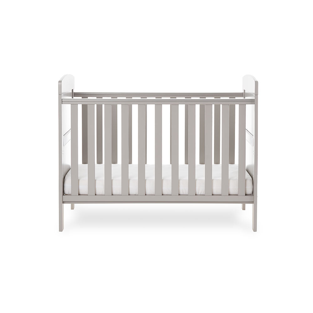 Cot Bed with solid ends, curved tops & base on the lowest setting. with teething rails on the side. 