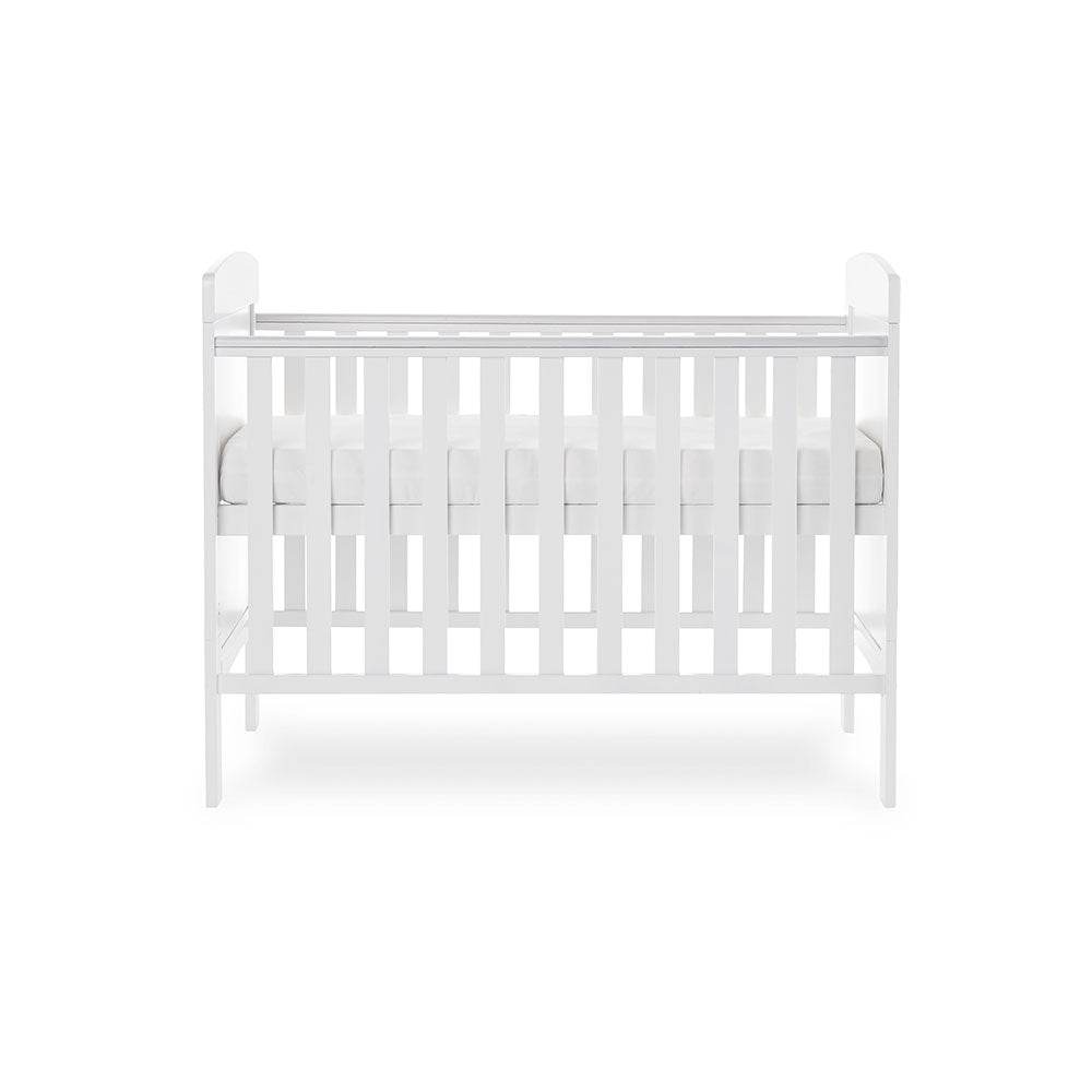 Mini Cot Bed with teething rails on the side, solid ends with curved top. Base on new born setting.
