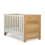Modern cot bed with oak effect head end & foot end, with sturdy white rails fitted with teething rails, gold hardware.