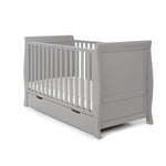 Sleigh Cot Bed with solid ends, curved edges, teething rails on the side rails. Base on the lowest setting. Under drawer included with cut out handles 