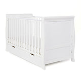 Sleigh Cot Bed with curved edges, solid ends, teething rails on the sides. Base on the lowest setting. Under drawer included with open cut out handles. 
