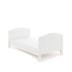 Cot bed in toddler bed mode, slatted ends finished with curved tops. 