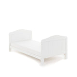 Cot bed in toddler bed mode, slatted ends finished with curved tops. 