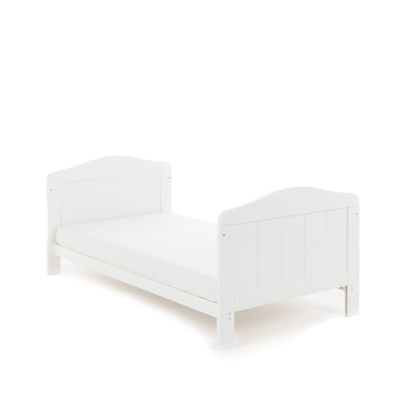 Cot bed in toddler bed mode, slatted ends finished with curved tops. 