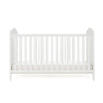 White Cot bed with base at its lowest setting, rails have teething rails, ends finished with curved top.