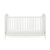 White Cot bed with base at its lowest setting, rails have teething rails, ends finished with curved top.