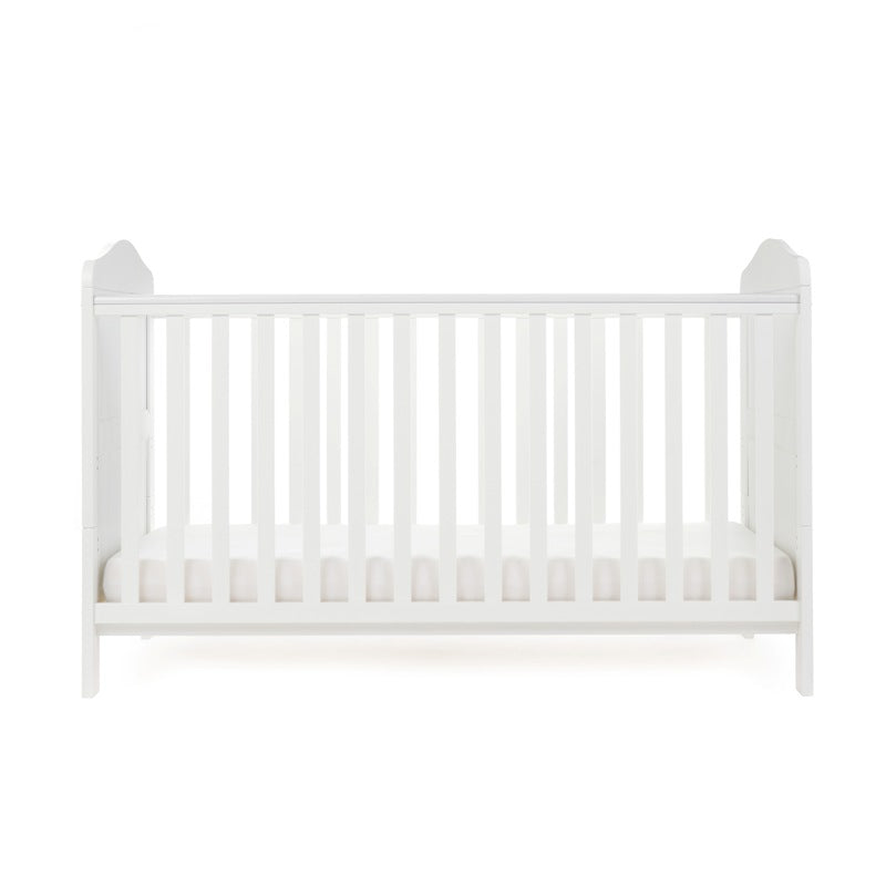 White Cot bed with base at its lowest setting, rails have teething rails, ends finished with curved top.